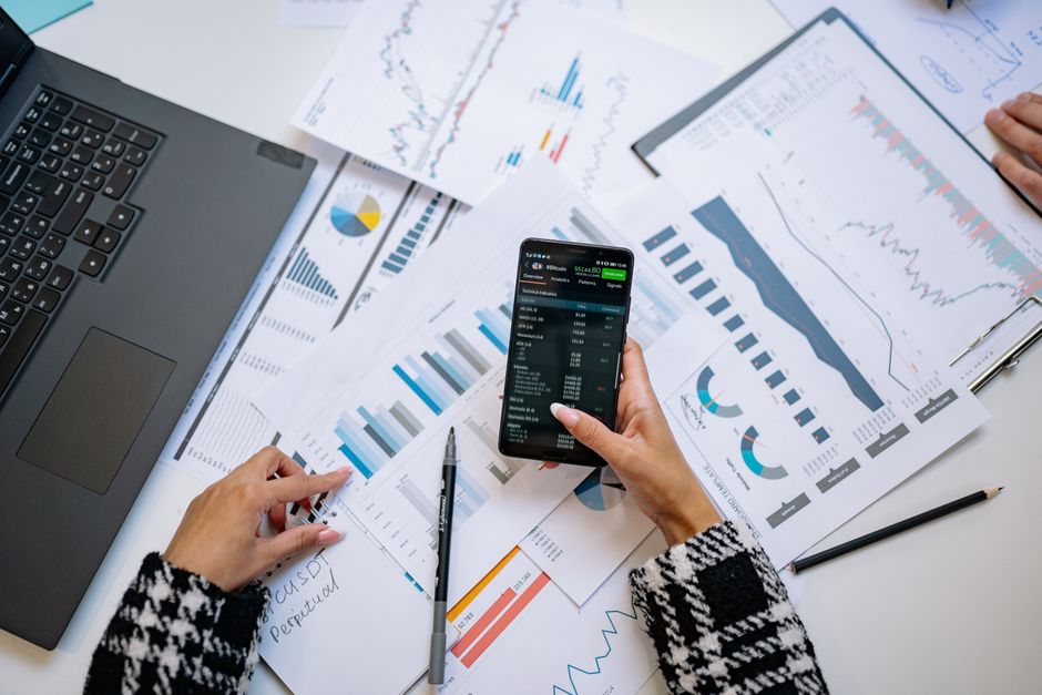 Algoritmo Redes Sociais — A top view on charts and smartphone in an office, showcasing data analytics.
