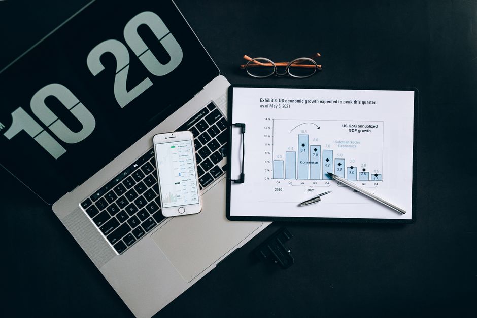 Algoritmo Redes Sociais — Top view of financial analysis tools on a desk including a laptop, smartphone, and graphs.
